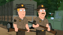 two sheriffs standing next to each other holding guns in front of a truck
