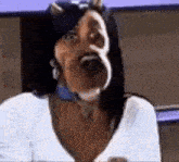 a woman with a very large nose is wearing a white shirt and sunglasses .