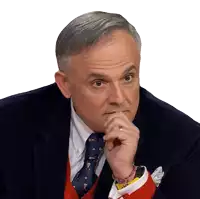 a man in a suit and tie holds his hand to his face