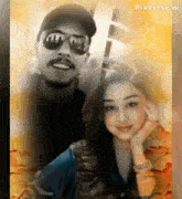 a man and a woman are posing for a picture . the man is wearing sunglasses and the woman is wearing a watch .