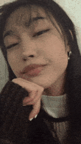a close up of a woman with her hand on her chin