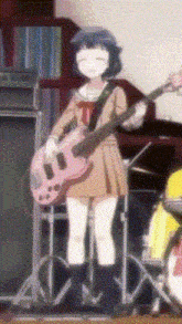 a girl in a school uniform is playing a pink guitar on a stage .