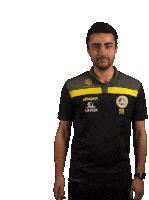 a man is wearing a black shirt that says uhlsport on it