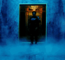 a person standing in front of a door with a chandelier hanging from it