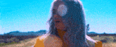 a woman wearing sunglasses and a yellow jacket is standing in a field