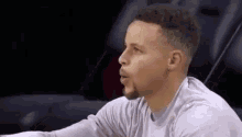 a close up of a basketball player sitting in a chair talking to someone .