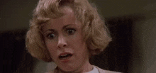 a woman is screaming in a room with her arms outstretched .