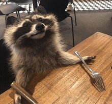 a raccoon is sitting at a table with a fork in its paw