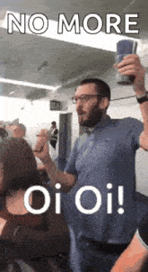 a man with a beard is holding a cup and says no more oi oi