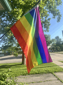 a rainbow flag is hanging from a pole outside