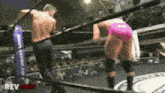 two men are wrestling in a ring and one of them is wearing a pink underwear