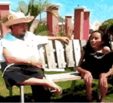 a man and a woman are sitting on a bench in a park