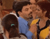 a man and a woman are dancing together in a crowd of people at a party .