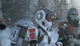a group of soldiers are standing in the snow holding guns .