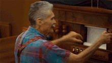an elderly man with a mustache is smiling while playing a musical instrument