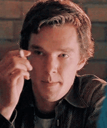 a young man is smoking a cigarette and looking at the camera .