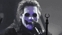 a man wearing a mask singing into a microphone