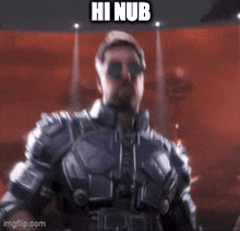 a man wearing sunglasses and a leather jacket is sitting in a chair and says hi nub .