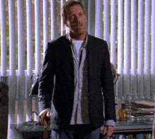 a man in a suit stands in front of a window