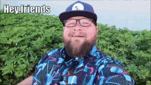 a man with a beard wearing a hat and glasses says hey friends