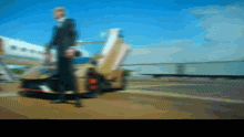 a blurry picture of a man standing next to a car with the door open