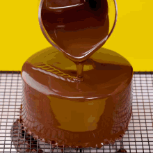 a chocolate cake is being covered in chocolate icing