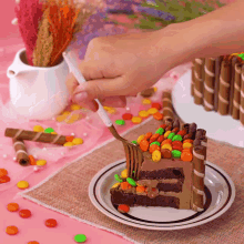 a person is cutting a slice of cake with candy on it