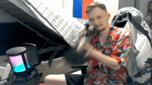 a man in a red shirt is holding a microphone in front of a russian flag