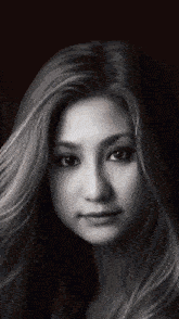 a black and white photo of a woman 's face with long blonde hair