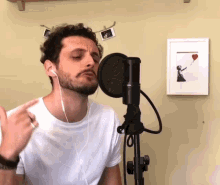 a man singing into a microphone with a picture of a girl holding a heart balloon behind him