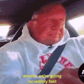 a man wearing a white sweatshirt with the word l on it is sitting in a car