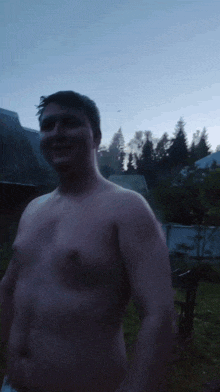 a man without a shirt is standing in the dark