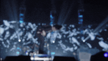 a blurred image of a person on a stage with the letter d in the lower right corner