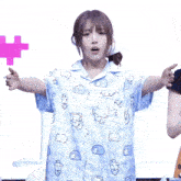 a girl wearing a blue shirt with a pattern of animals is standing in front of a sign that says bacterial 6