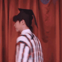 a young man wearing a graduation cap and gown is walking on a stage .