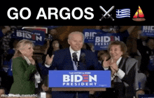 joe biden giving a speech in front of a crowd with a sign that says biden president