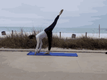 a woman doing a yoga pose on a blue mat