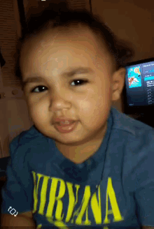 a baby wearing a blue shirt that says nirvana on it