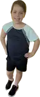 a young girl wearing a blue shirt and black shorts smiles for the camera