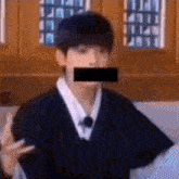 a man with a black tape over his mouth is making a funny face .
