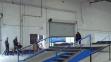 a man riding a skateboard down a ramp in a warehouse
