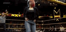 a wrestler is laying on the ground in a wrestling ring with the word nxt in the background .
