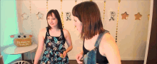 two women are standing in front of a sign that says ultimate tuff n 's