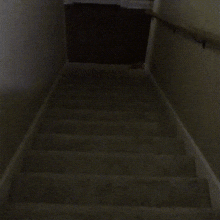 a staircase in a dark room with a handrail