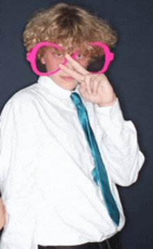a boy wearing a white shirt and blue tie is wearing pink glasses