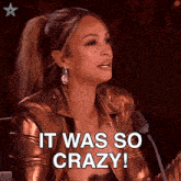 a woman in a metallic jacket says " it was so crazy " in front of a microphone