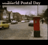 a red mailbox on the side of a street with the words world postal day