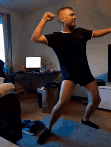 a man in a black shirt is flexing his muscles