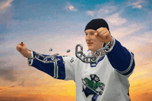 a man in a hockey jersey is holding a chain