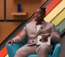a man in a suit is sitting in a chair